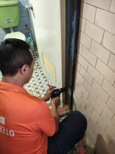 技術人員針對潮濕的廁所木門框進行微創鑽孔灌注藥劑,建立長效防護帶,阻絕白蟻沿著門框向上蔓延。